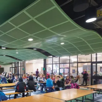 Green abstract noise absorber ceiling panel hanging over school tables